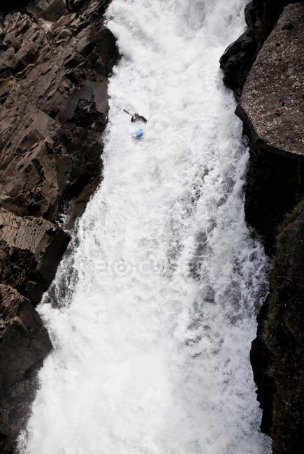 Homem canoagem sobre cachoeira rochosa — Fotografia de Stock