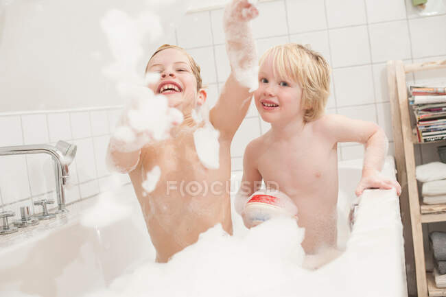 Brüder spielen mit Seifenlauge in der Badewanne — Stockfoto
