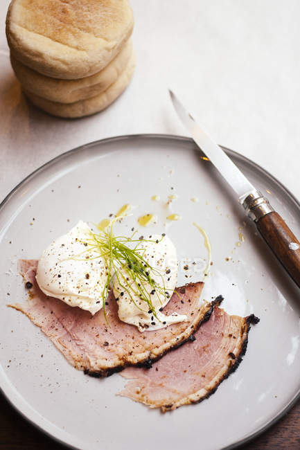 Cold meat and poached eggs served on plate — Stock Photo