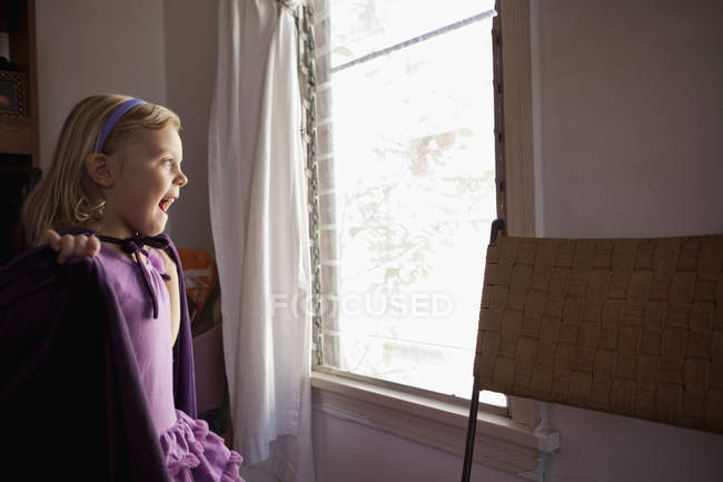Portrait of young girl looking out of window — Stock Photo