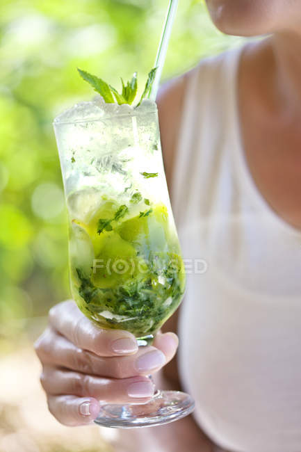 Cropped image of Woman holding glass of mojito — Stock Photo