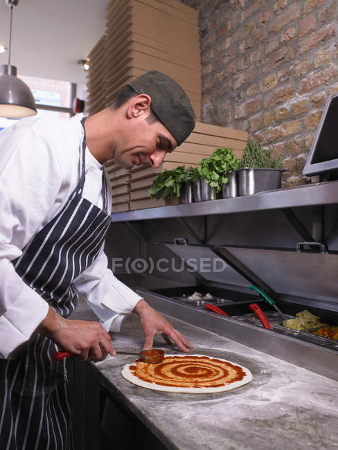 Pizzabäcker macht Pizza in der Küche — Stockfoto
