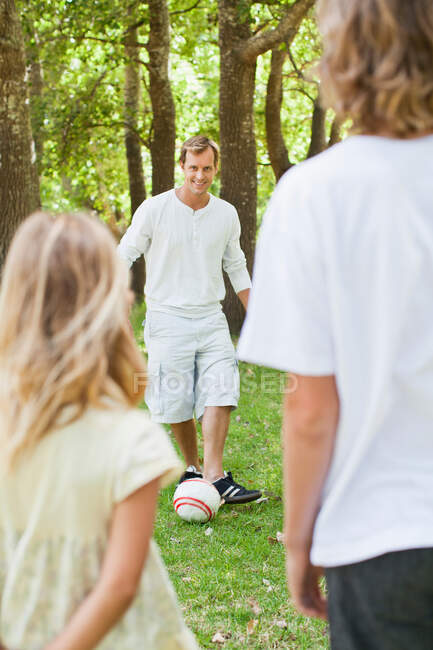 Father and children playing in park — Stock Photo