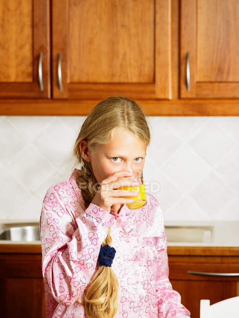 Young girl in kitchen drinking — Stock Photo