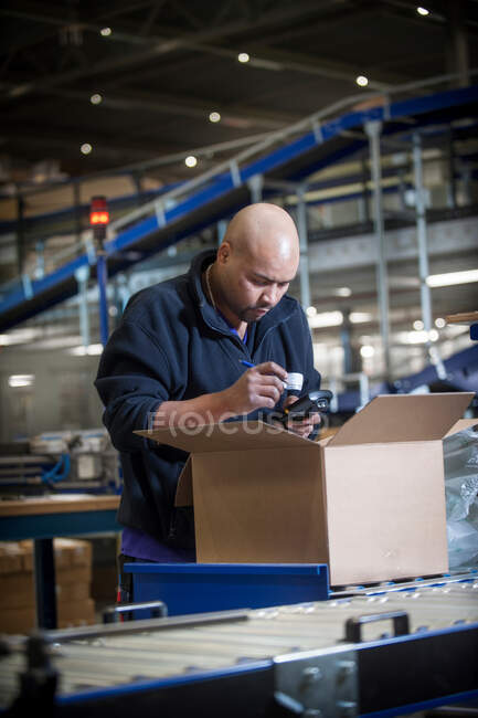 Ouvrier d'entrepôt masculin utilisant un scanner de code à barres — Photo de stock
