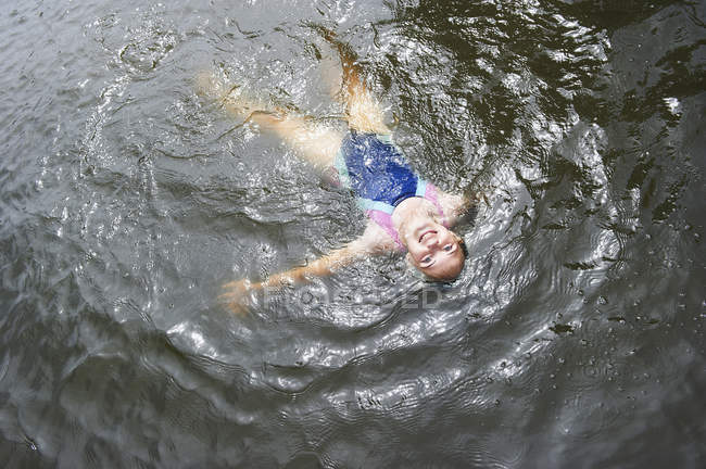Visão aérea da menina nadando no lago rural — Fotografia de Stock