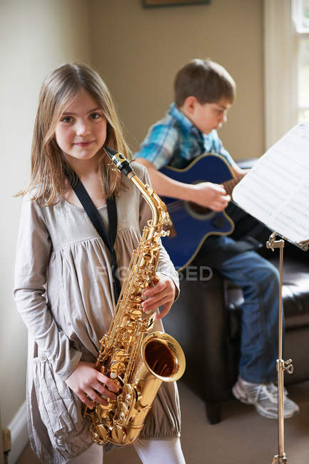 Улыбающаяся девушка играет на саксофоне — стоковое фото