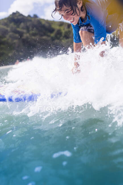 Rapaz surfista cavalgando a onda — Fotografia de Stock
