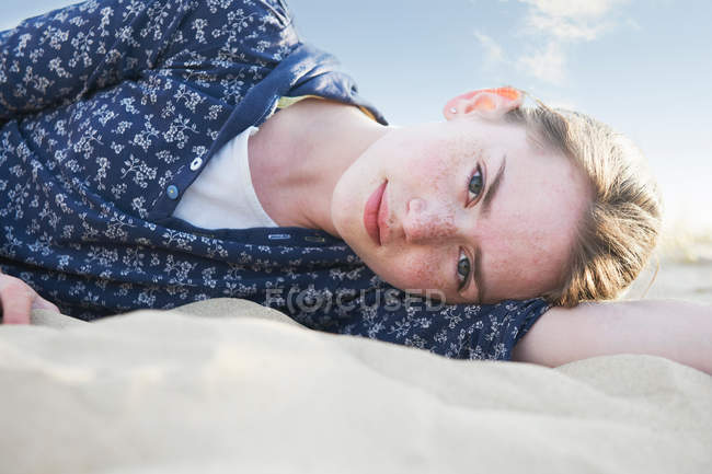Дівчинка-підліток лежачи на пляжі пісок — стокове фото