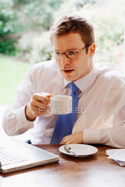 Geschäftsmann benutzt Laptop beim Frühstück — Stockfoto
