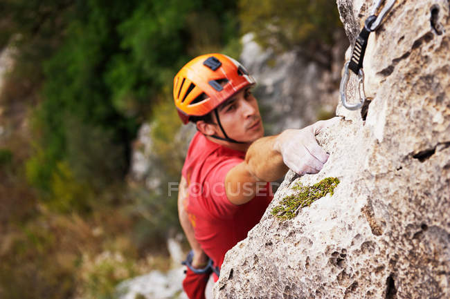 Hombre escalando el acantilado al día - foto de stock