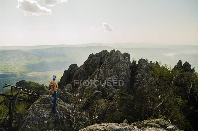 Rear view of teenage boy hiking on rugged rock formation, Russia — Stock Photo