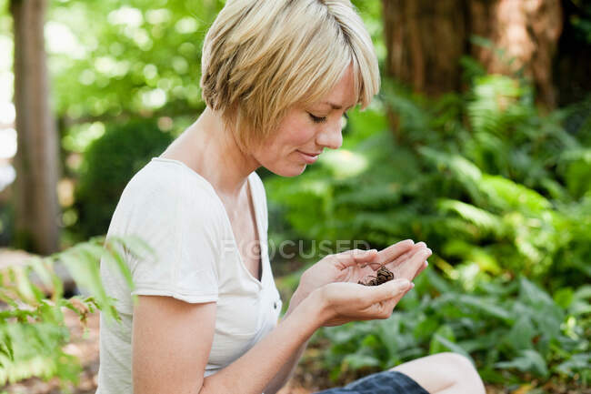Junge Frau sitzt im Garten — Stockfoto