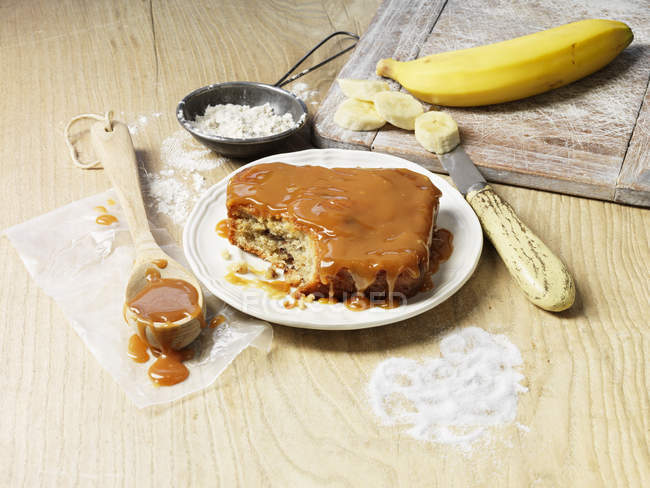 Gâteau banane et caramel avec des ingrédients sur la table — Photo de stock