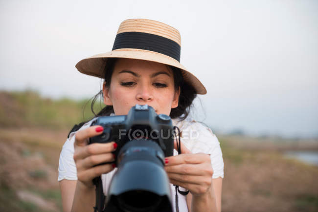 Femme portant un chapeau prenant des photos — Photo de stock