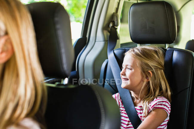 Girl smiling in backseat of car — Stock Photo