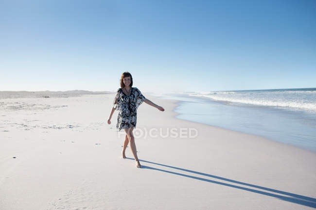 Дівчина гуляє на піщаному пляжі — стокове фото