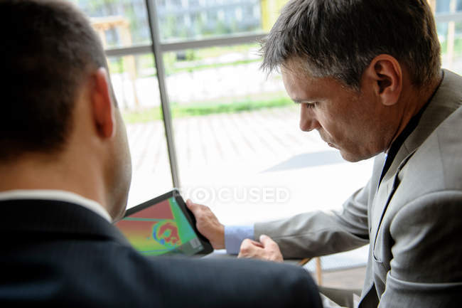 Empresários usando tablet computador na mesa — Fotografia de Stock