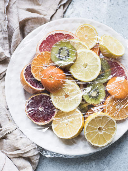 Sliced citrus fruits on a plate — Stock Photo