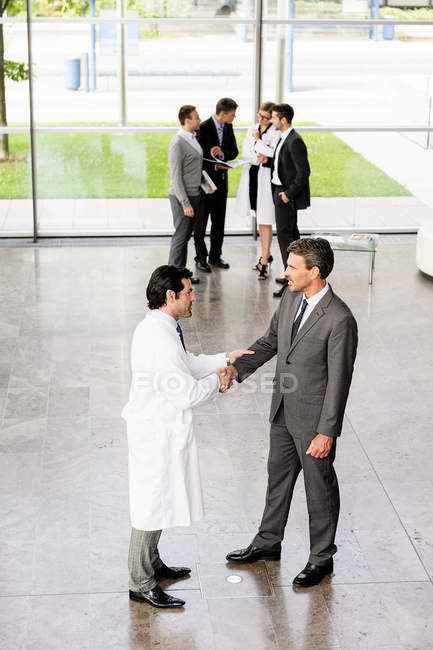 Business people and doctors greeting — Stock Photo