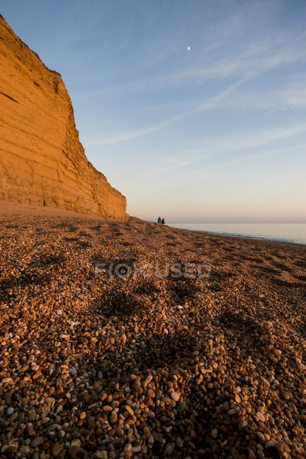Playa de tejas y acantilados al atardecer, Burton Bradstock, Dorset, Reino Unido - foto de stock