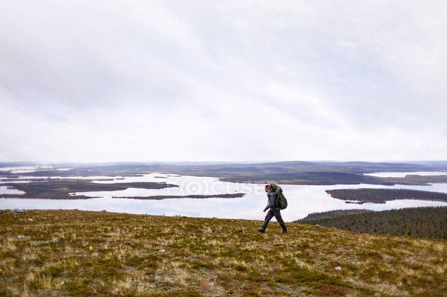 Hiker walking with backpack on trail, Lapland, Finland — Stock Photo