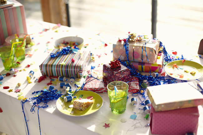 Table laid for birthday party with gifts and streamers — Stock Photo