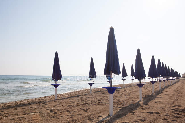 Filas de sombrillas de playa cerradas - foto de stock
