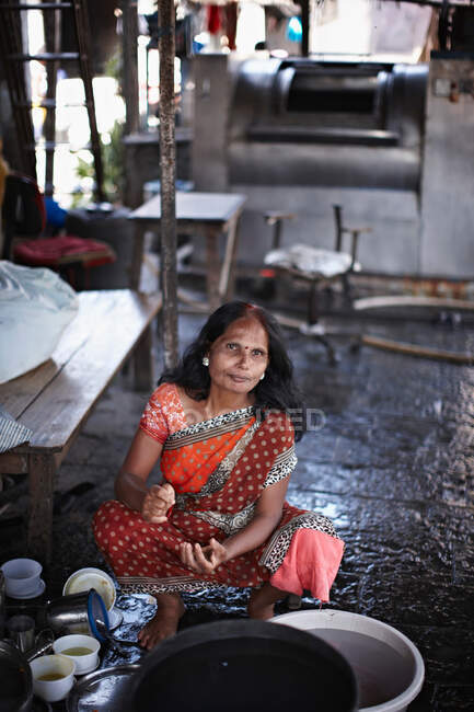 Mujer cocinando en bata tradicional - foto de stock