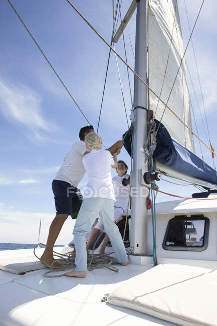 Padre e fratelli che trasportano la vela in catamarano vicino a Fuerteventura, Spagna — Foto stock
