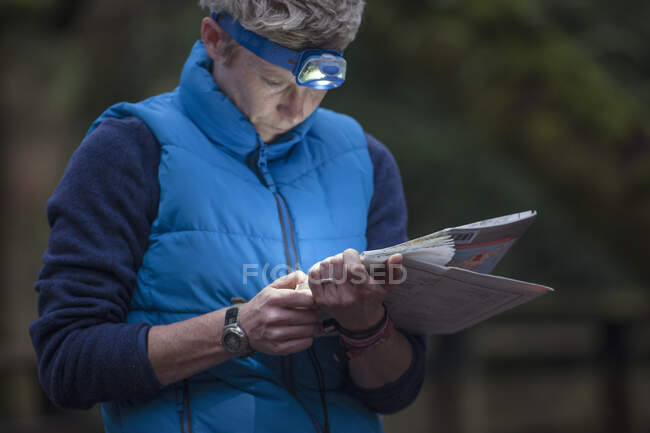 Mulher adulta média estudando mapa — Fotografia de Stock