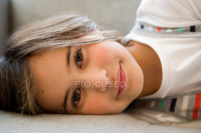 Menina deitada e olhando para a câmera — Fotografia de Stock