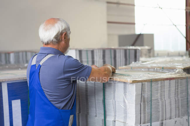 Trabalhador da fábrica em movimento e empilhamento de papelão — Fotografia de Stock