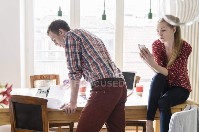 Jeune couple travaillant à la maison — Photo de stock