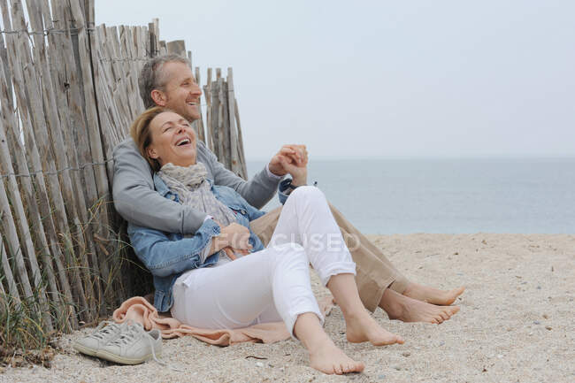 Літня пара обіймається на пляжі — стокове фото