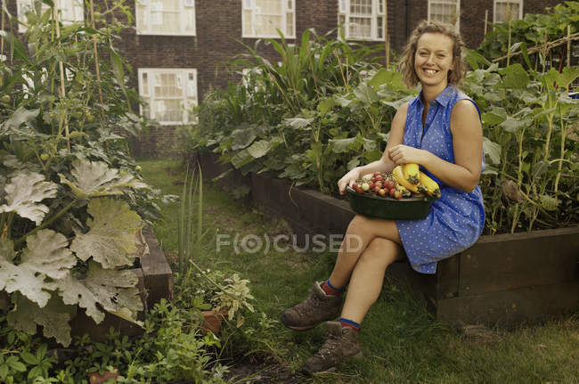 Young woman with harvested vegetables on council estate allotment — Stock Photo