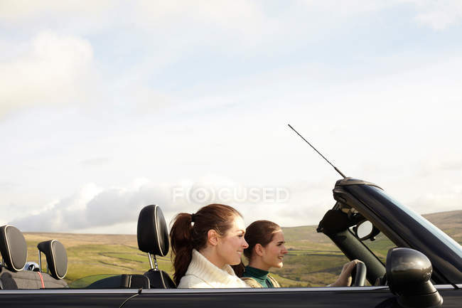 Mulheres dirigindo na paisagem rural — Fotografia de Stock