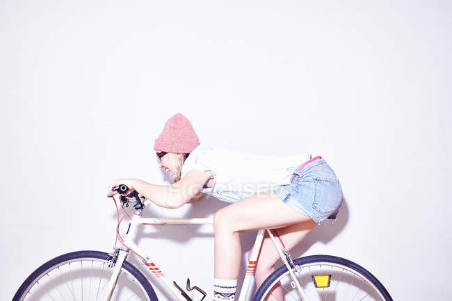 Junge Frau lehnt sich auf Fahrrad nach vorne — Stockfoto