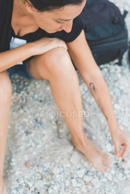 Woman playing with pebbles on beach — Stock Photo