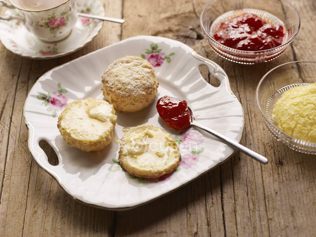 Fresh baked scones with jam and clotted cream — Stock Photo