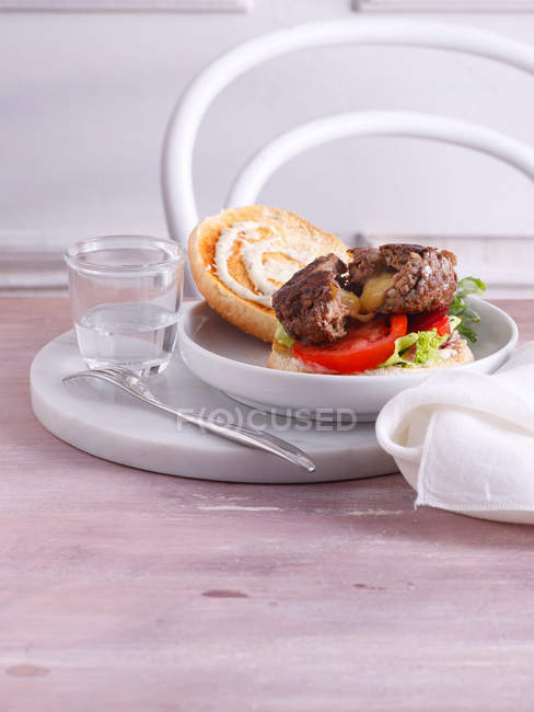 Piatto di hamburger con bicchiere d'acqua — Foto stock