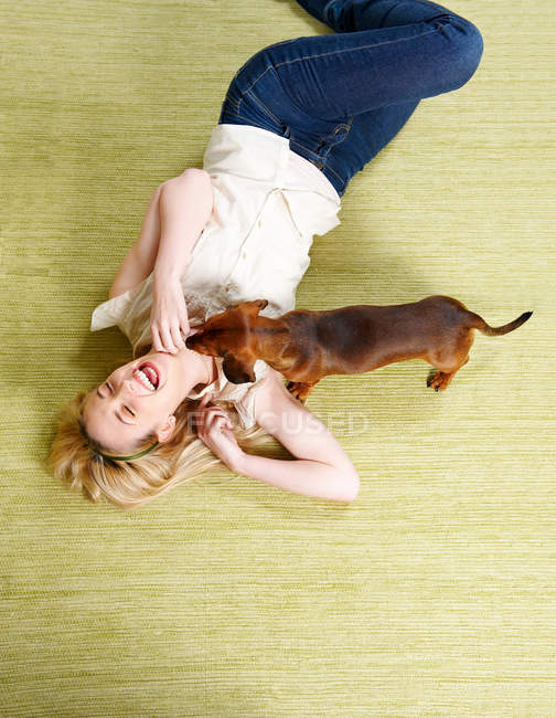 Mujer joven jugando con el perro - foto de stock