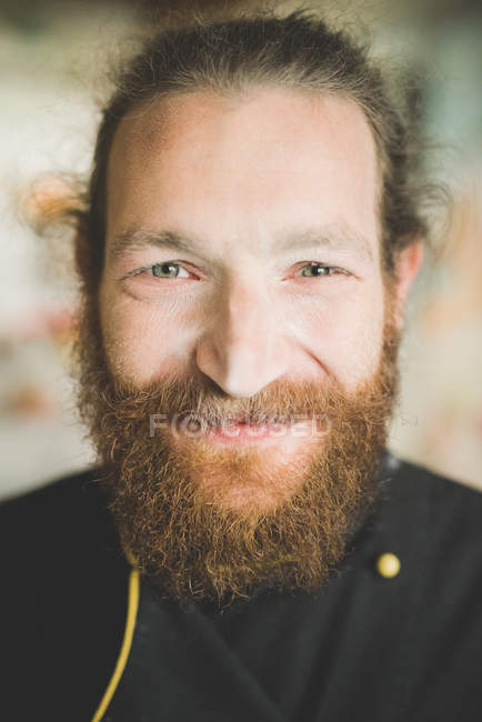 Retrato de hombre adulto medio barbudo mirando a la cámara sonriendo - foto de stock