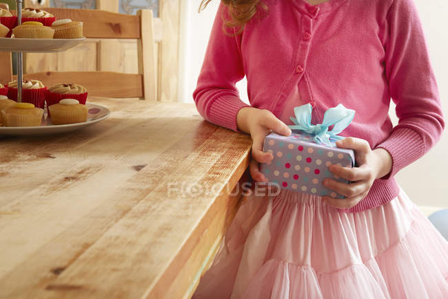 Девушка держит подарок на день рождения, в середине секции — стоковое фото