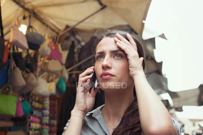 Молода жінка на мобільний телефон, ринку Сан-Лоренцо, Флоренції, Тоскана, Італія — стокове фото