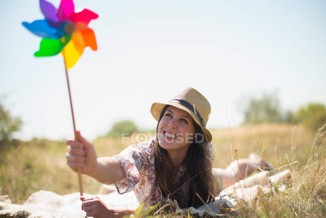 Mulher deitada na frente segurando moinho de vento — Fotografia de Stock