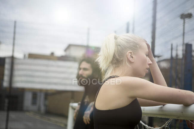 Jeune femme prenant une pause, s'appuyant sur le but de football — Photo de stock