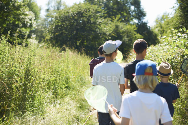 Group of boys walking in sunny field — Stock Photo