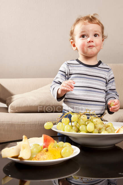 Niño comiendo uvas - foto de stock