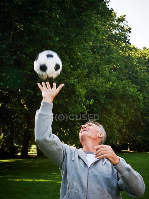 Человек ловит мяч в парке — стоковое фото